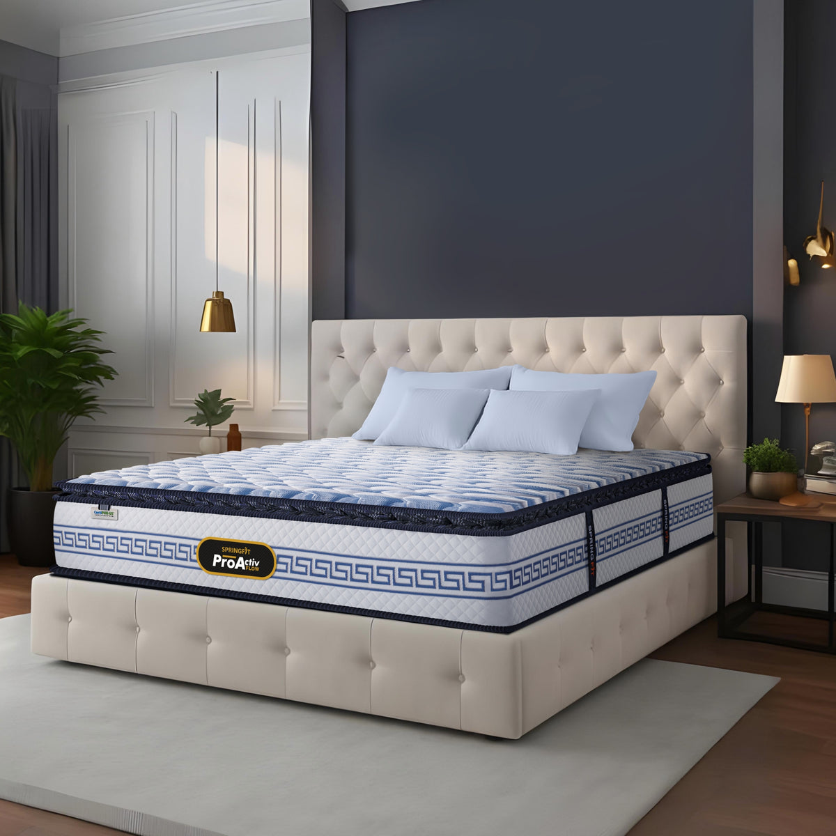 Springfit ProActiv Flow mattress on beige tufted platform bed in elegant navy and white bedroom with gold pendant lights, light blue pillows, and decorative plants